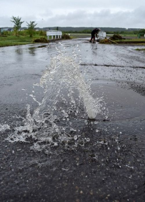 nước phun ra từ một hố ga trên đường sau trận mưa lớn ở hidaka, hokkaido nước phun ra từ một hố ga trên đường sau trận mưa lớn ở hidaka, hokkaido